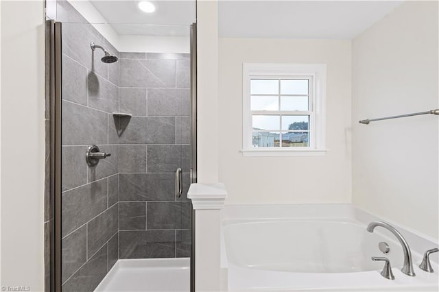 bathroom with a shower stall and a garden tub