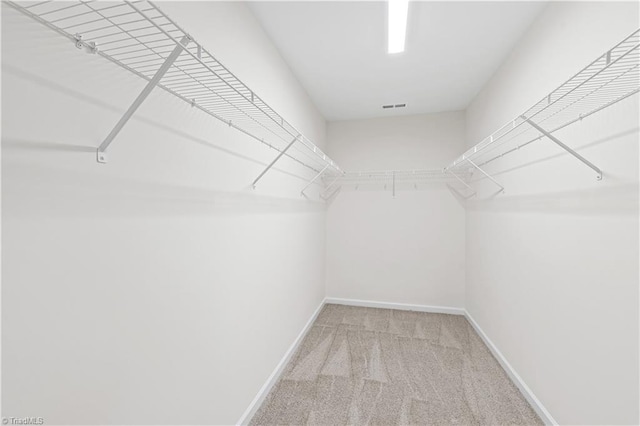 spacious closet with light colored carpet and visible vents