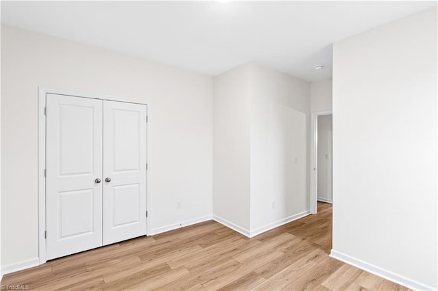 unfurnished room with baseboards and light wood finished floors