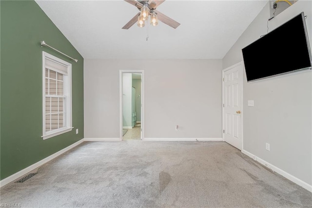 empty room with lofted ceiling, light colored carpet, and ceiling fan