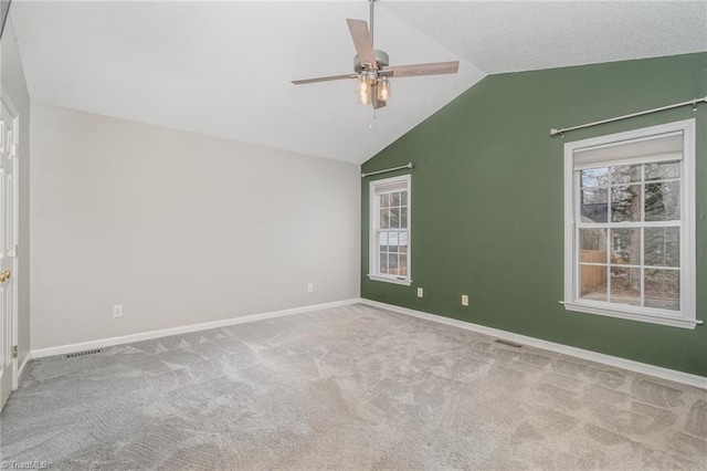 spare room featuring lofted ceiling, light colored carpet, and ceiling fan