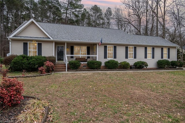 ranch-style home with a porch and a lawn