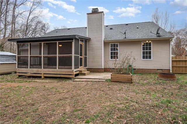 rear view of property with a sunroom and a patio area