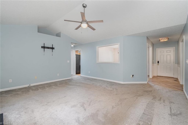 spare room featuring vaulted ceiling, light carpet, and ceiling fan