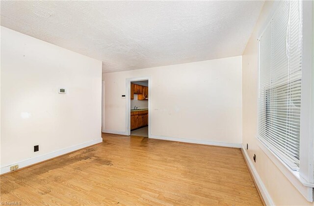 800 Essex Rd, Winston-Salem, NC 27105 - unfurnished room featuring light wood-type flooring, a textured ceiling, and baseboards