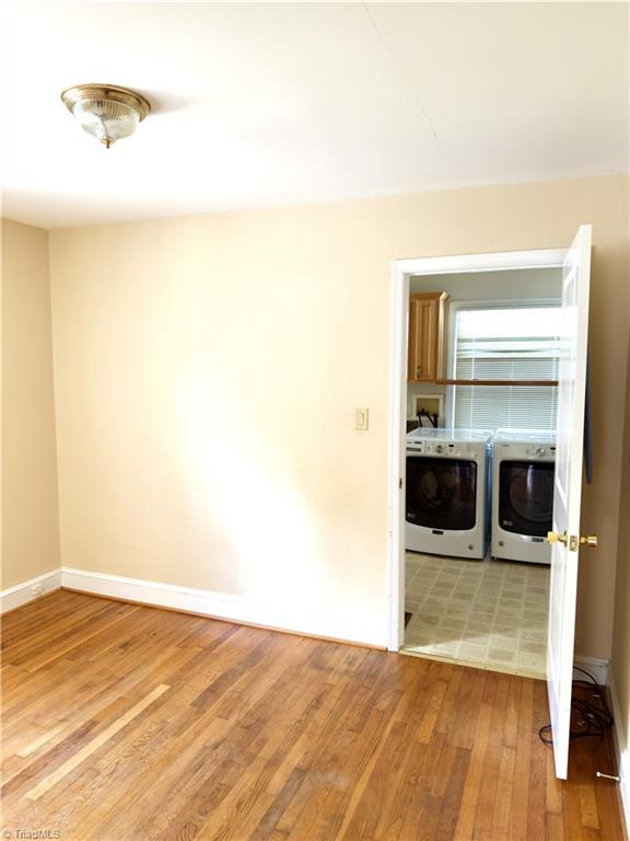 211 Hermitage Rd, Greensboro, NC 27403 - empty room featuring washer and clothes dryer, light wood finished floors, and baseboards