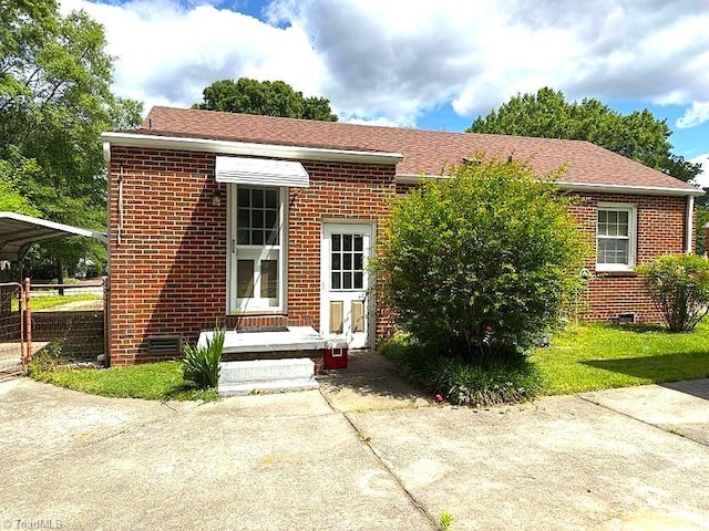 211 Hermitage Rd, Greensboro, NC 27403 - view of front of property featuring a detached carport, brick siding, and roof with shingles