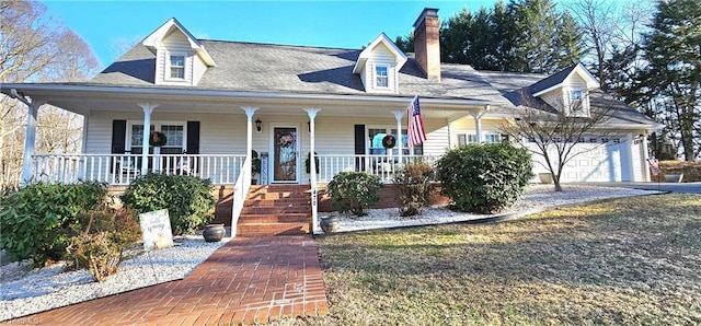 new england style home featuring a porch, a chimney, and an attached garage