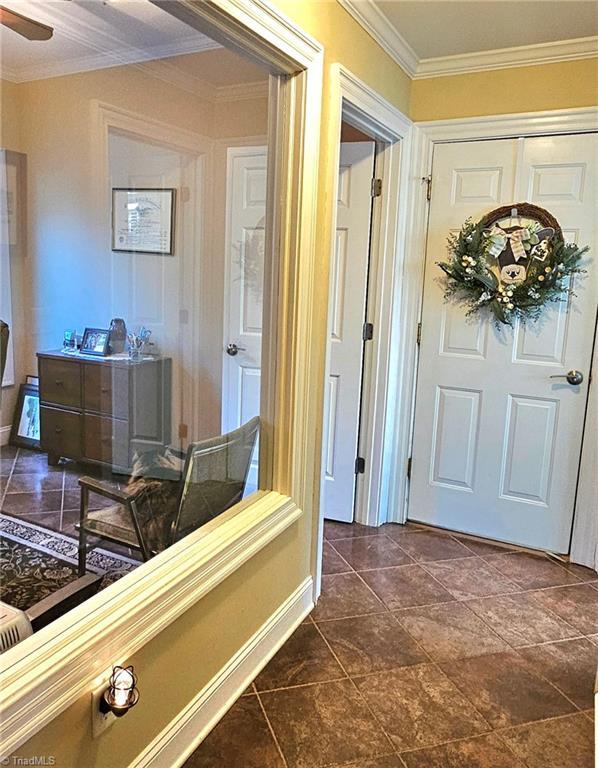 corridor with baseboards and crown molding