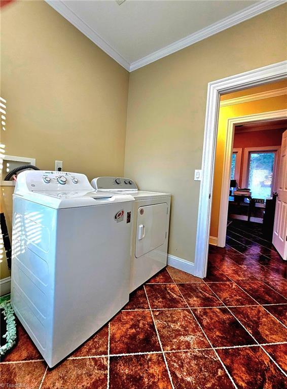 laundry room with crown molding, laundry area, independent washer and dryer, and baseboards