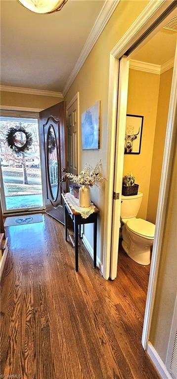 interior space with crown molding, dark wood finished floors, and baseboards