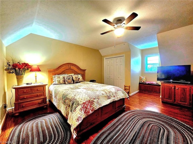 bedroom featuring lofted ceiling, dark wood-style flooring, a textured ceiling, and baseboards