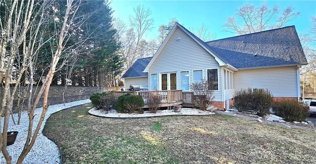 exterior space with a shingled roof, fence, and a deck