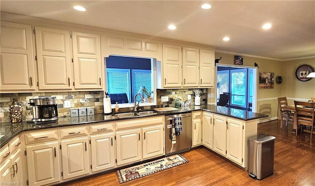 kitchen featuring dishwasher, wood finished floors, a peninsula, crown molding, and a sink