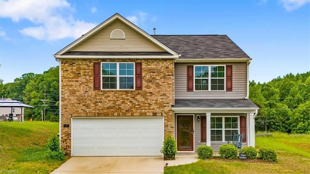 traditional-style house with concrete driveway, a garage, brick siding, and a front yard