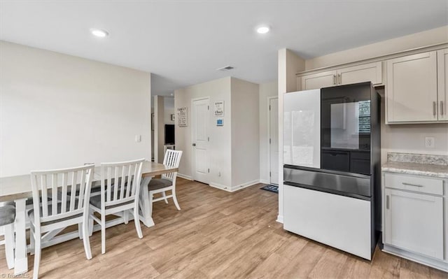 kitchen with light wood-type flooring, light countertops, baseboards, and recessed lighting