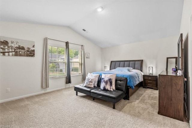 bedroom with lofted ceiling, light carpet, and baseboards