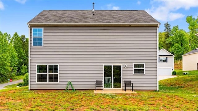 back of house with a yard, a garage, and a patio area