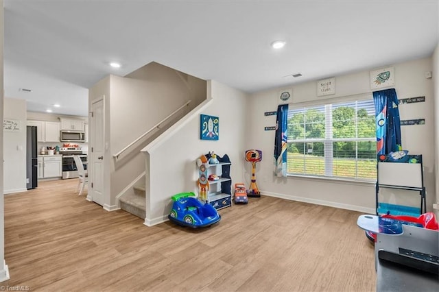 playroom with baseboards, light wood finished floors, and recessed lighting