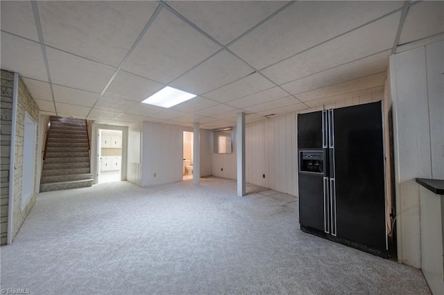 basement with black fridge, carpet floors, and a paneled ceiling