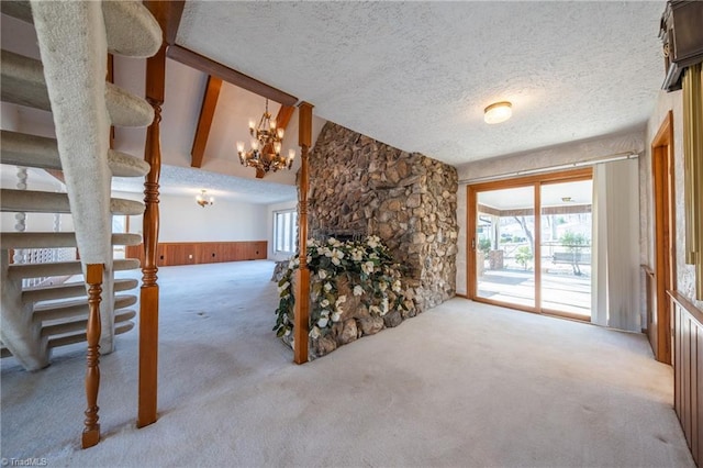 unfurnished living room with a healthy amount of sunlight, light carpet, a fireplace, and a textured ceiling