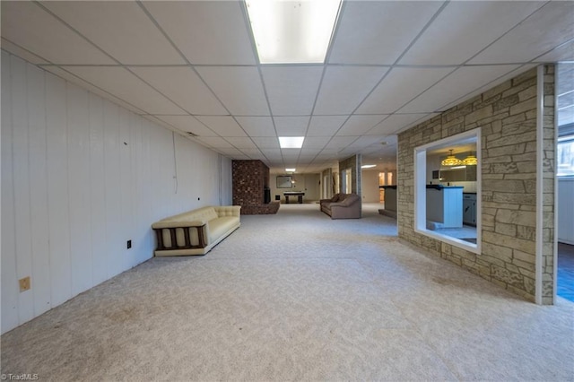 basement with a large fireplace, a paneled ceiling, and carpet