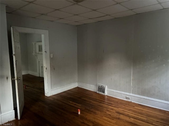 unfurnished room featuring a drop ceiling and dark hardwood / wood-style flooring