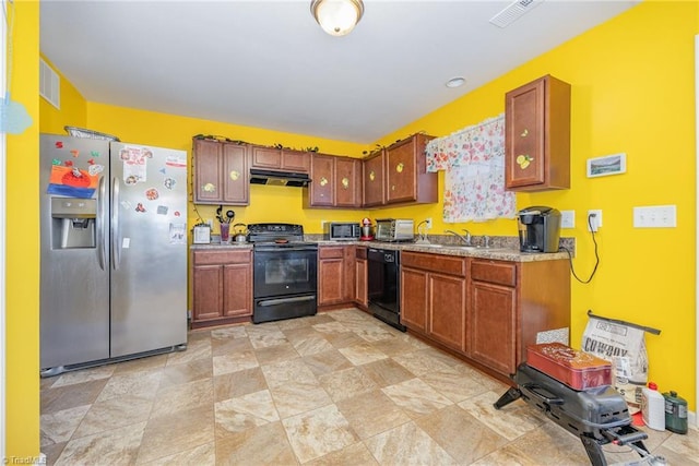 kitchen featuring black appliances, under cabinet range hood, a sink, and visible vents