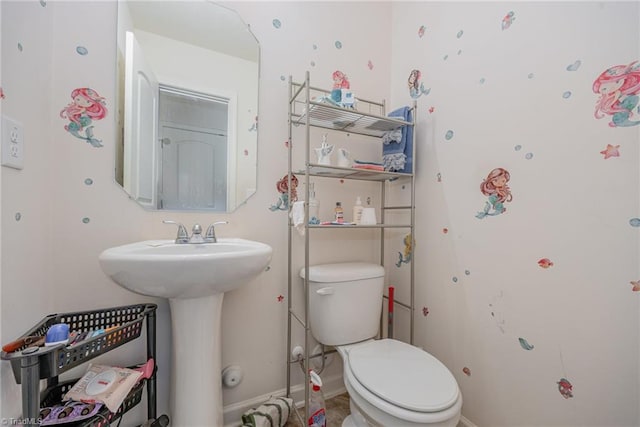 bathroom with baseboards and toilet