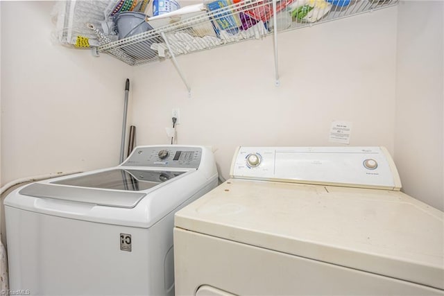 clothes washing area with washing machine and clothes dryer and laundry area