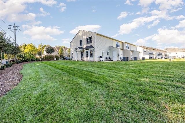 back of property featuring central AC unit and a yard