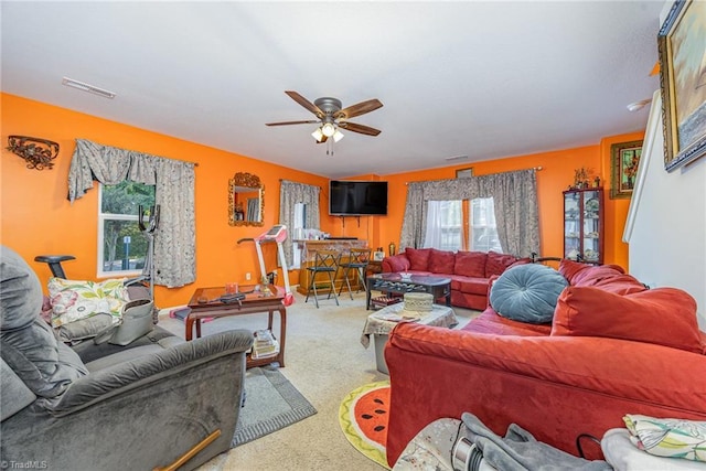 carpeted living area featuring ceiling fan and visible vents