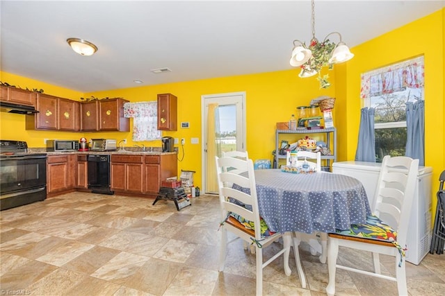kitchen with under cabinet range hood, black appliances, brown cabinets, pendant lighting, and a notable chandelier