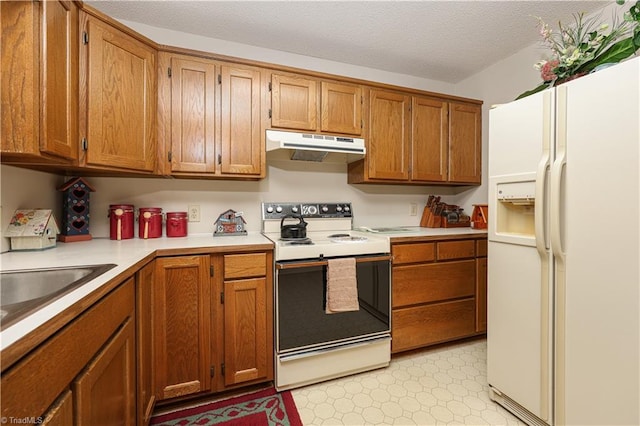 kitchen with white appliances, a textured ceiling, and sink