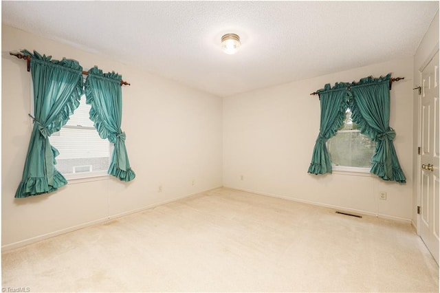 unfurnished room with a textured ceiling and carpet floors