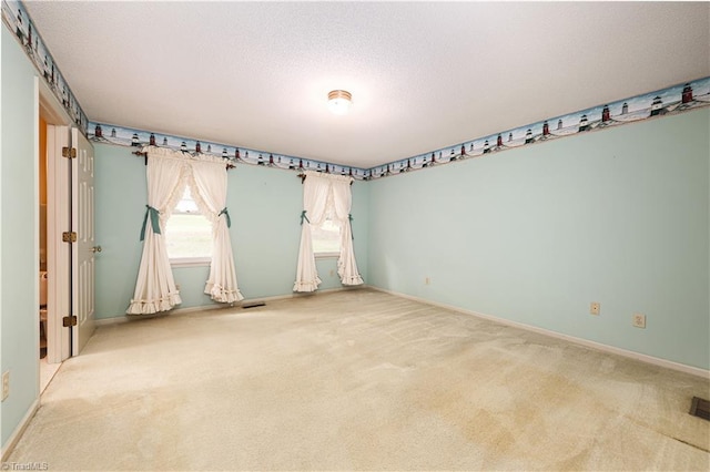 carpeted spare room with a textured ceiling