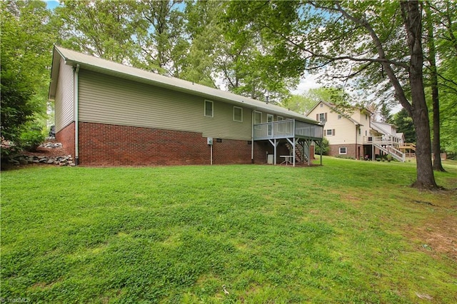 rear view of house with a deck and a lawn