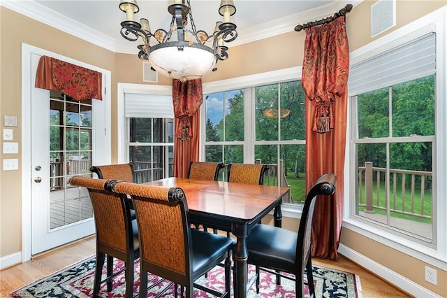 dining area with crown molding, light wood finished floors, baseboards, and a chandelier