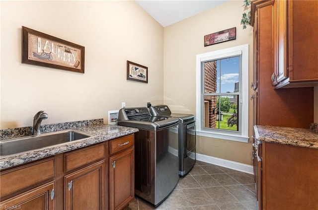 washroom featuring cabinet space, washer and clothes dryer, dark tile patterned floors, and baseboards