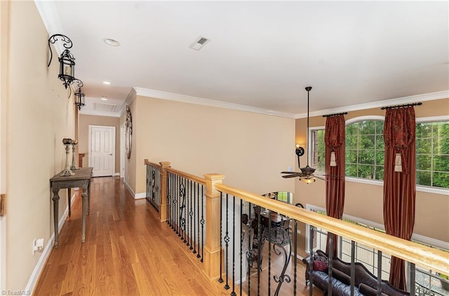 hallway with wood finished floors, baseboards, ornamental molding, recessed lighting, and an upstairs landing
