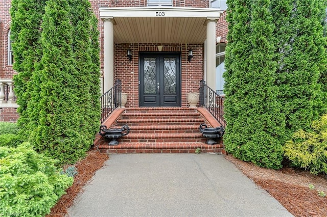 doorway to property featuring french doors and brick siding