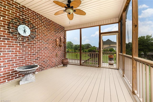 unfurnished sunroom featuring a ceiling fan