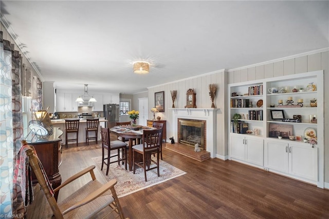 dining room with ornamental molding, dark wood-style flooring, and a fireplace