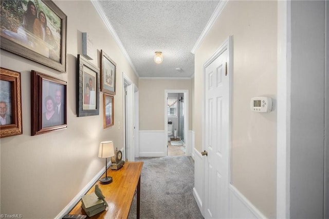 hall with carpet floors, crown molding, and a textured ceiling