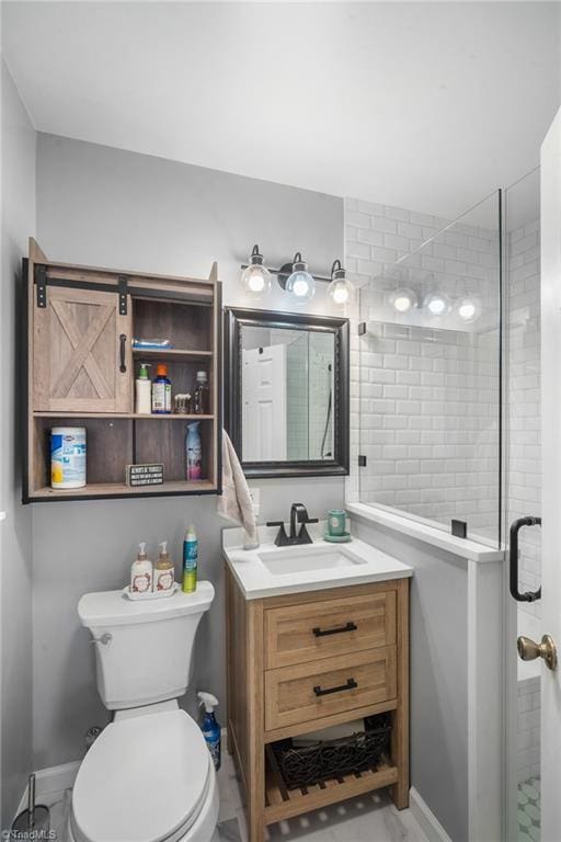 bathroom featuring toilet, a stall shower, vanity, and baseboards