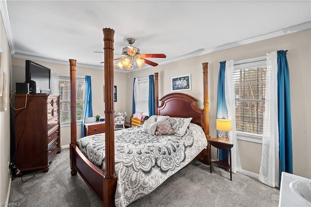 carpeted bedroom with ceiling fan, baseboards, and crown molding