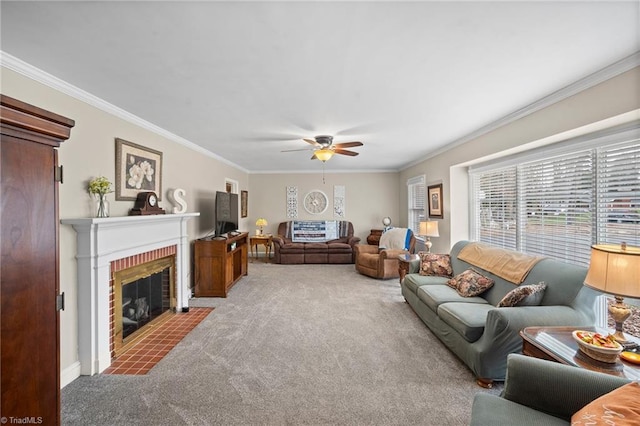 living area featuring ceiling fan, carpet floors, a brick fireplace, and crown molding