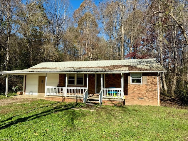 ranch-style home featuring covered porch and a front lawn