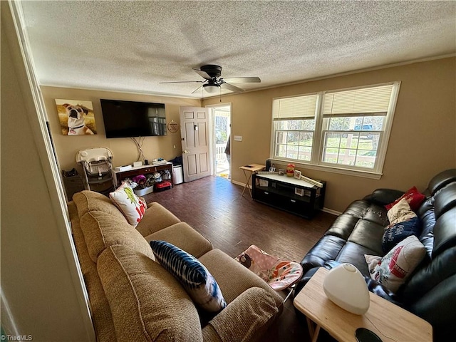 living room with a textured ceiling, ceiling fan, and dark wood-type flooring