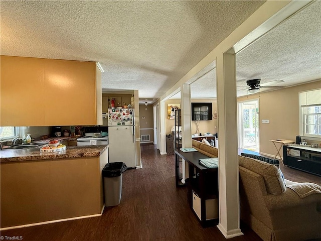 kitchen with dark wood-type flooring, sink, ceiling fan, a textured ceiling, and white fridge